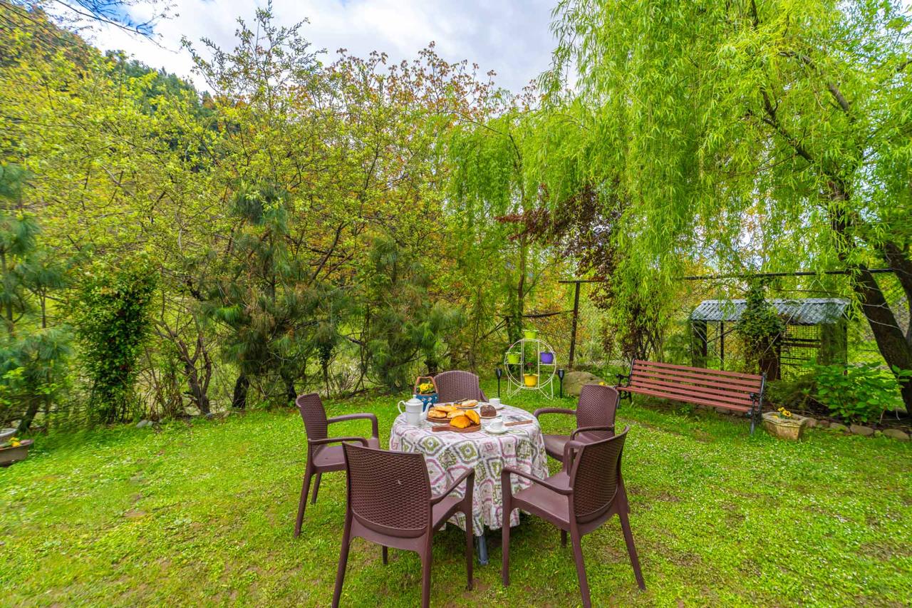 Sitting area table chairs in garden maryam cottage
