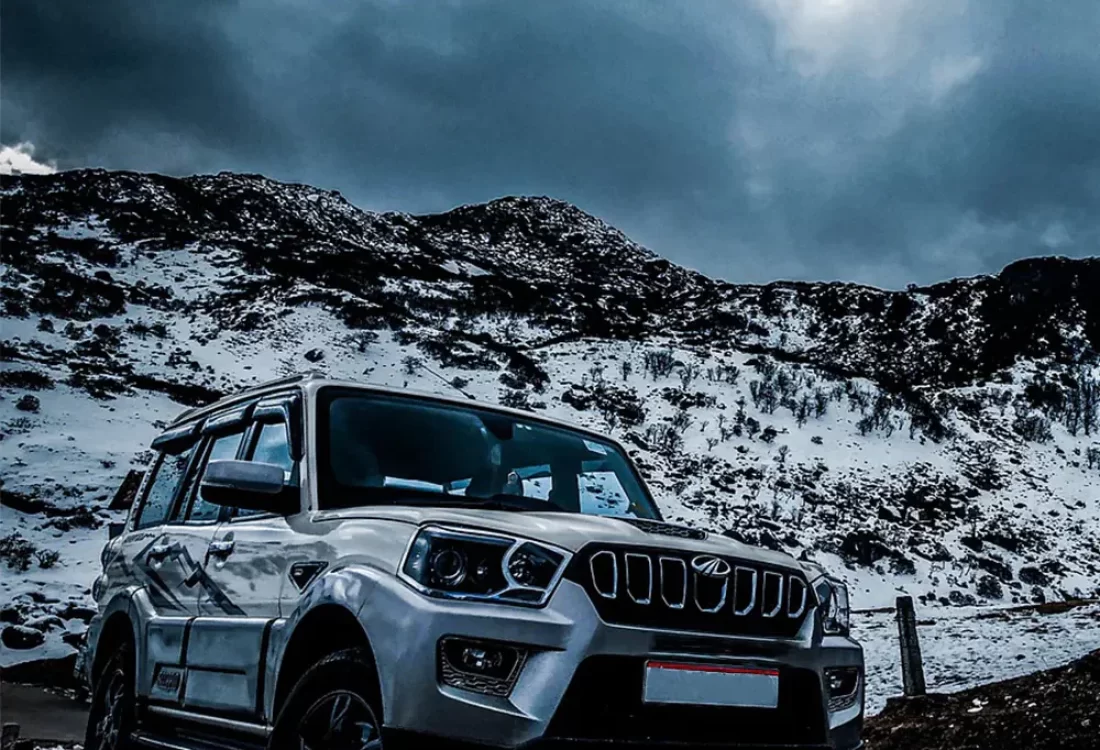 Mahindra scorpio with snow-capped mountain behind it
